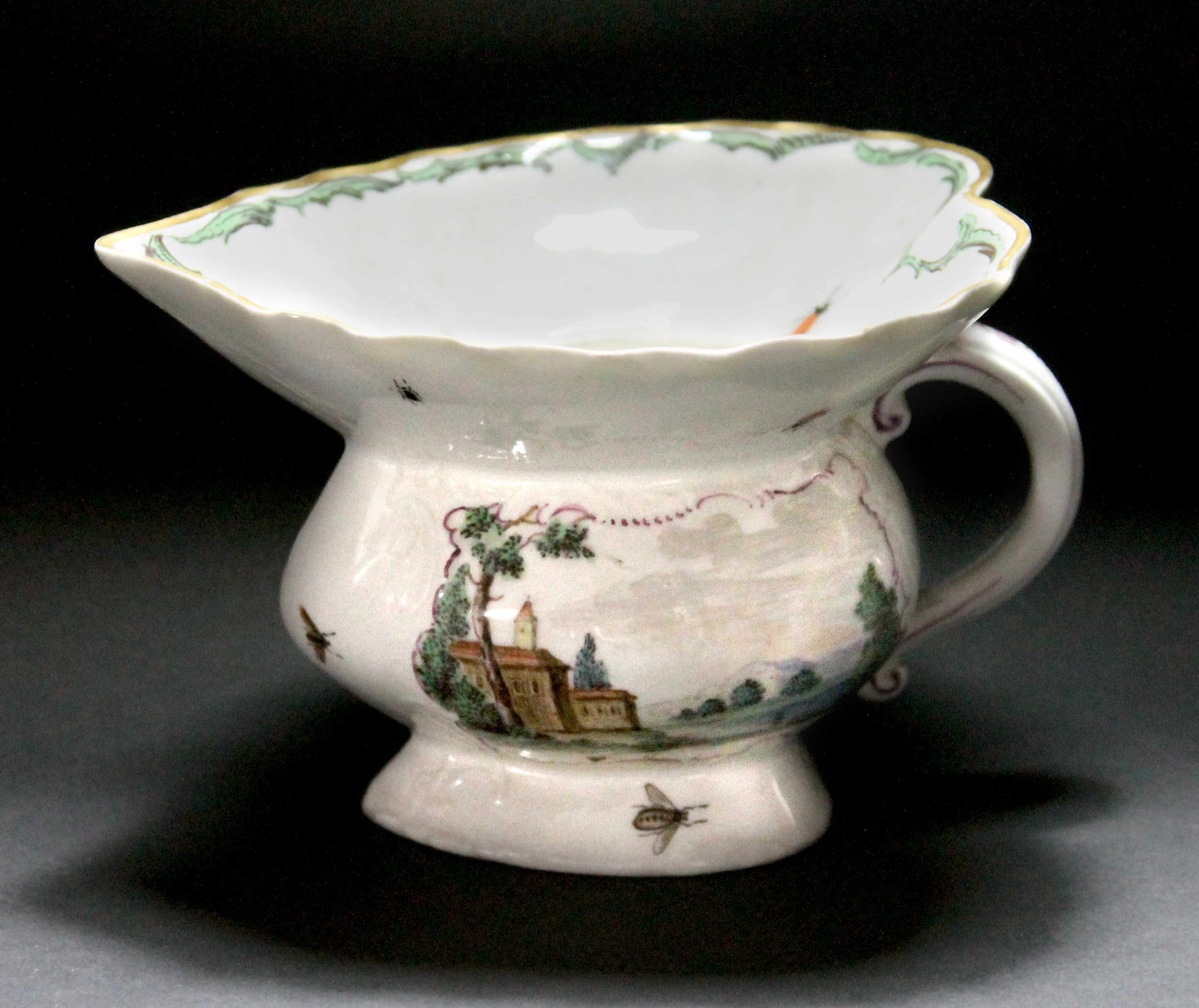 A Hochst porcelain spitoon, 18th century, decorated with puce landscape vignettes (a.f), 8.8cm high,