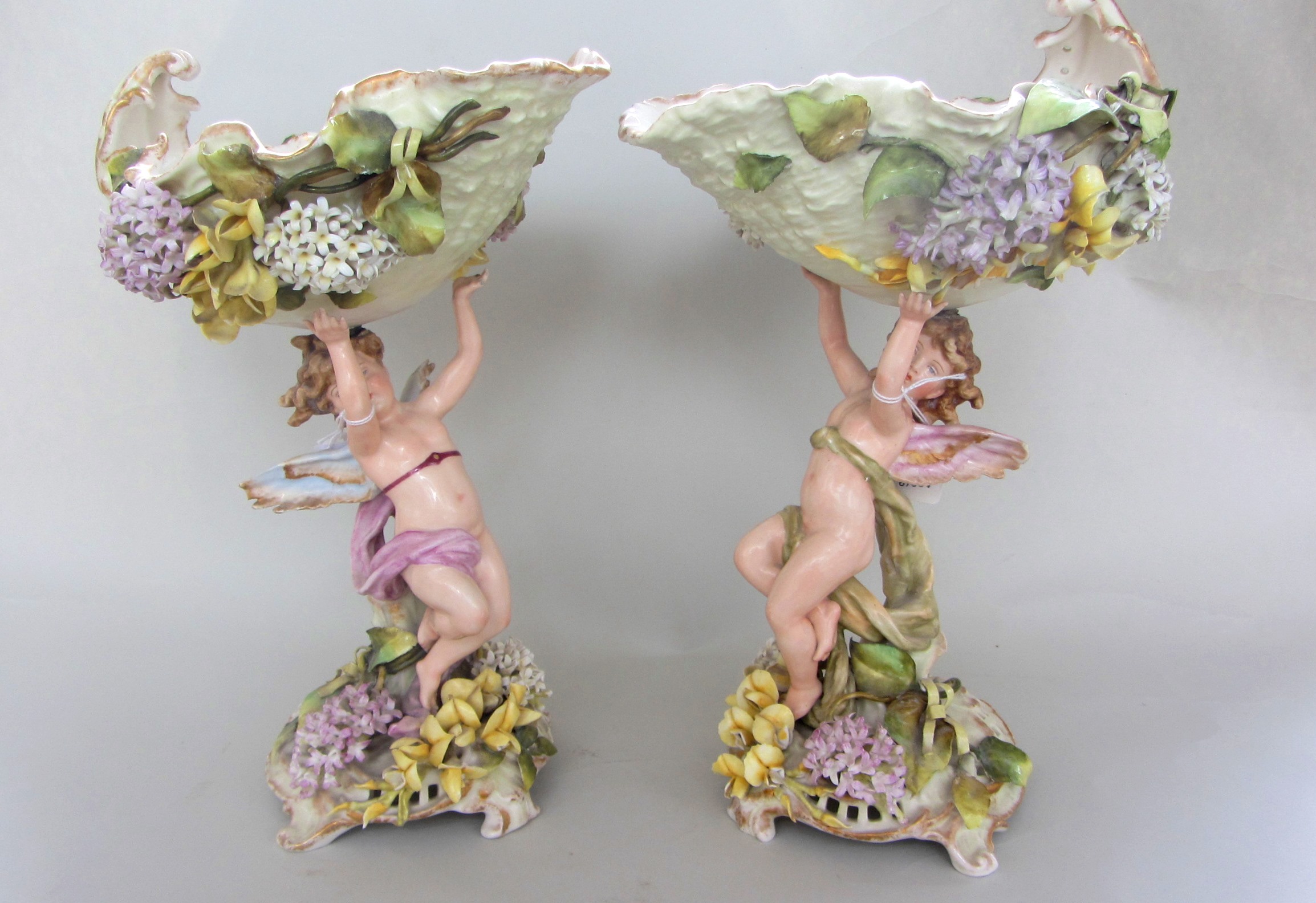 A pair of Sitzendorf figural centrepieces, early 20th century, each floral encrusted pierced bowl
