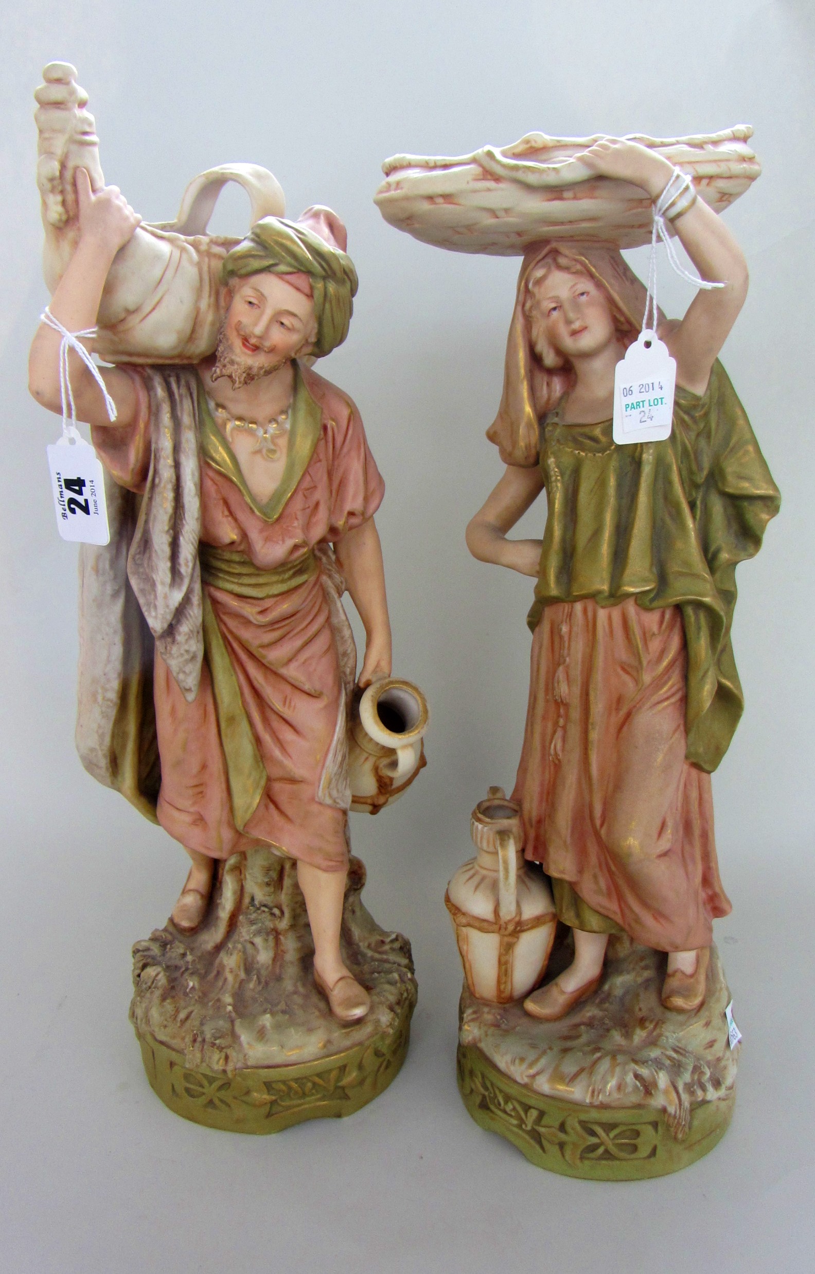 A pair of Royal Dux blush ivory biscuit porcelain figures, each modelled as a Continental water