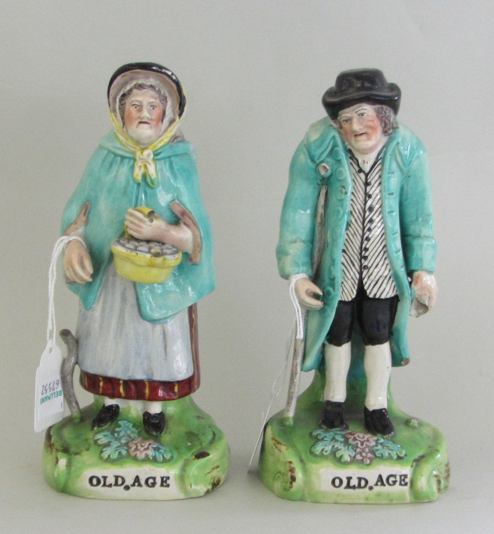 A pair of Staffordshire pearlware figures, 'Old Age', each depicting an elderly Lady and Gentleman