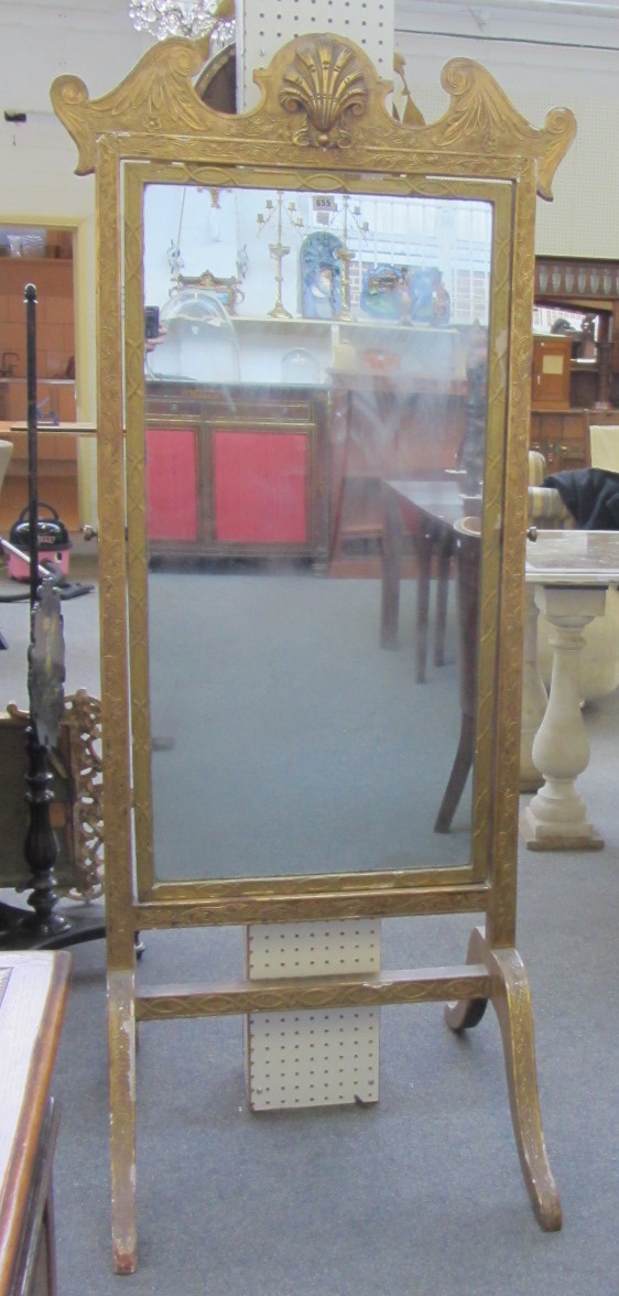 A 19th century gilt framed cheval mirror with shell mounted crest and four downswept supports,