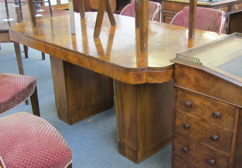 An Art Deco figured walnut dining room suite, the shaped rectangular dining table on slab