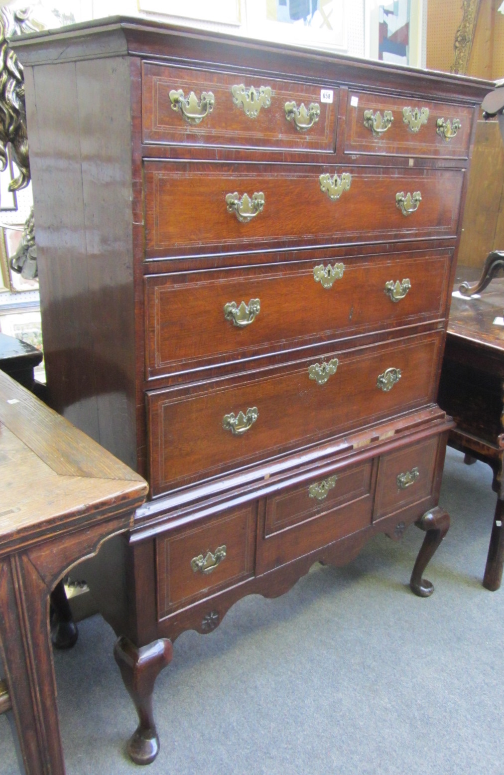 An 18th century feather banded oak chest on stand, of two short and three long graduated drawers,