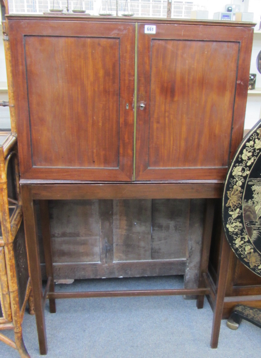 An early 19th century mahogany two door collectors chest with fitted pigeon hole interior on later