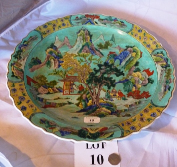 A large Chinese charger decorated with figures in a landscape on a green ground est: £200-£300 (A3)