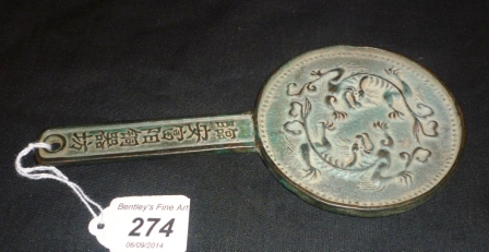 A Chinese mirror with dragons and inscription to handle est: £40-£60