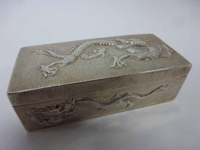 A late 19th/early 20th Century Chinese Wang Hing & Co. silver box with dragons in relief on a