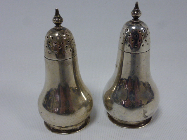 Pair of silver pepperettes, hallmarked Sheffield 1920 by maker Harry Atkin, 8.5cms in height, 125g