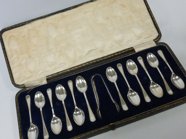 A cased set of twelve silver teaspoons with bright cut decoration, hallmarked Sheffield 1921, by