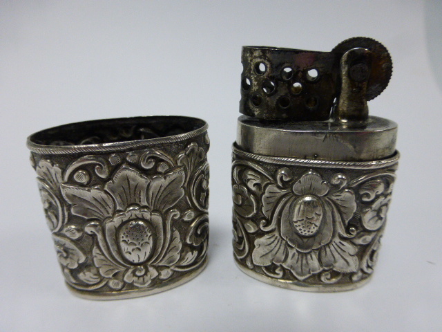 A Continental silver cased cigarette lighter with embossed foliate design, stamped 800, 6.2cms in