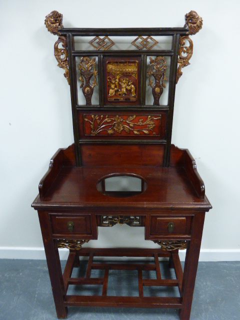 An early 20th Century Chinese lacquered washstand with gilded dragon finials and central figural