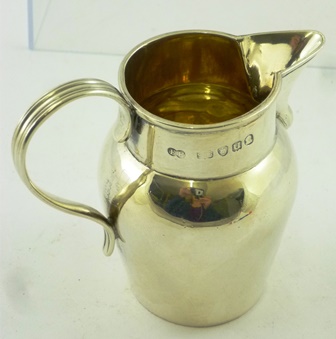 F** E** A GEORGE III SILVER CREAM JUG having rolled rim and baluster body with reeded handle, - Image 4 of 6