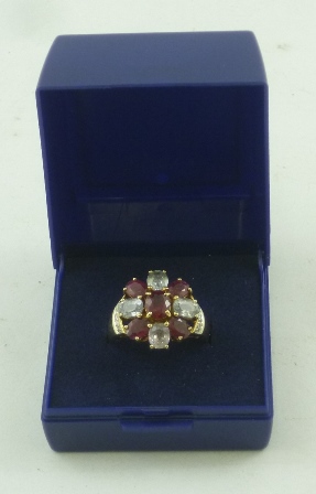 A 9ct GOLD DRESS RING having an oval head set with a star of five rubies interset with four pale