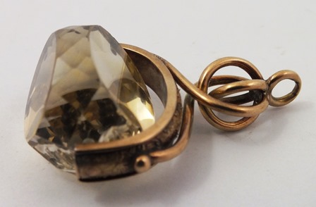 A GOLD COLOURED METAL SEAL fashioned as a triple facetted citrine with entwined wire head