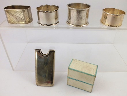 A SELECTION OF FOUR DISSIMILAR SILVER NAPKIN RINGS, all engraved, and a VISITING CARD SLIDE,