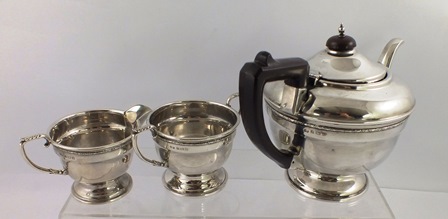 T** S** A THREE-PIECE SILVER TEASET, each of spun circular form having applied scroll wire rim,