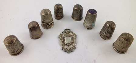 A SELECTION OF NINE SILVER AND SILVER COLOURED METAL THIMBLES, including one repousse worked ""To