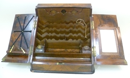 A VICTORIAN WALNUT TABLE TOP STATIONERY BOX having sloping front with twin figured opening doors,