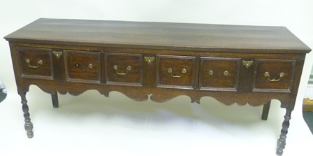 A PART 18TH/19TH CENTURY OAK DRESSER BASE with later alterations, having plank top over 3 double