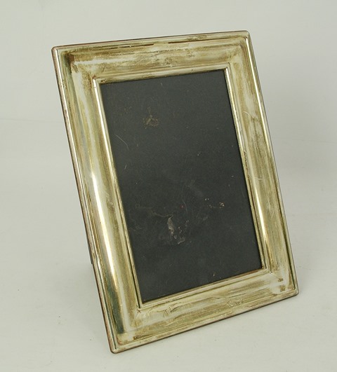 CARR A RECTANGULAR SILVER PHOTOGRAPH FRAME having moulded style surround, on mahogany finished