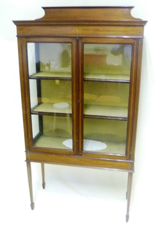 A LATE VICTORIAN MAHOGANY DISPLAY CABINET having upstand over twin glazed doors, shelved interior,