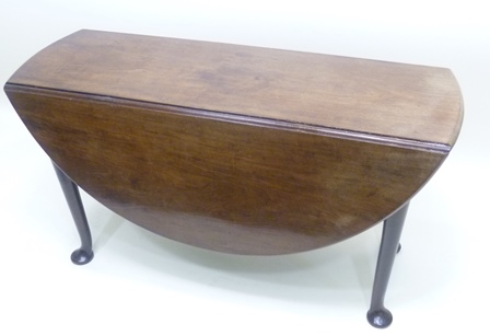 A GEORGE III MAHOGANY DINING TABLE having circular drop-flap top, raised upon tapered legs with pad