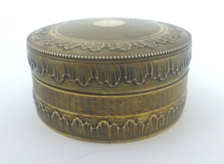 A FOREIGN SILVER GOLD COLOURED METAL CIRCULAR TACK BOX, having push fit engine turned lid and