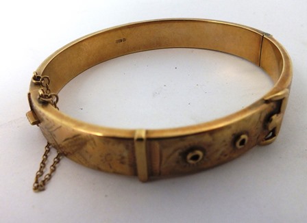A 9ct GOLD BUCKLE BANGLE with bright cut decorated top 15g