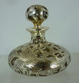 BLACKSTARR & FROST AN EARLY 20TH CENTURY AMERICAN SILVER COLOURED METAL OVERLAID SCENT BOTTLE AND