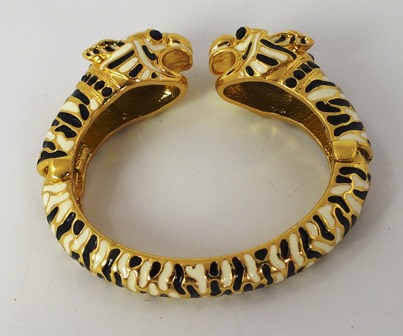 A BUTLER & WILSON GILT METAL ENAMELLED BANGLE fashioned as twin leopard heads with white and black
