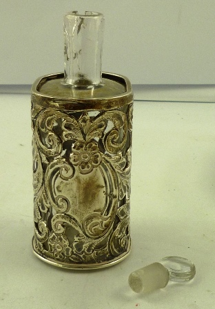A SILVER SLEEVED CLEAR GLASS PERFUME BOTTLE cylindrical with long neck and stopper, the sleeve