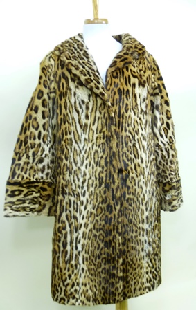 AN OCELOT FUR COAT with lapel collar and wide bell sleeves, deep cuffed, concealed hook fasteners