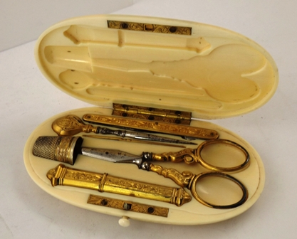 A 19TH CENTURY FRENCH BONE NECESSAIRE having oval hinged case with black inked period monogram, the