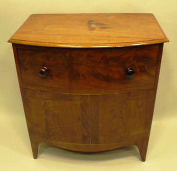 A 19TH CENTURY MAHOGANY FINISHED BOW FRONT LIFT-UP COMMODE on slender plain feet, 70cm x 66cm