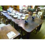 A VICTORIAN MAHOGANY EXTENDING DINING TABLE having twin squared ends with rounded corners, raised on