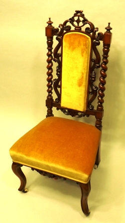 A VICTORIAN WALNUT BEDROOM CHAIR having fretted crest rail, barley twist uprights with knops,