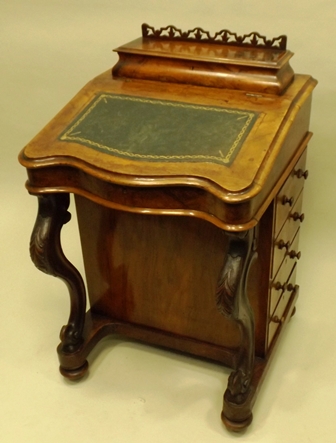 A VICTORIAN WALNUT DAVENPORT having pen box top and slope front, later green skiver, four flank