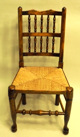 A SET OF SIX SUFFOLK STYLE ELM & ASH DINING CHAIRS each having a spindle back, rush seat, turned