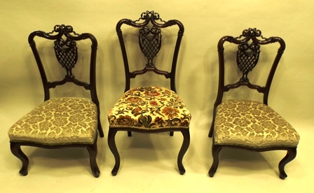 A VICTORIAN MAHOGANY PARLOUR SUITE each piece having an ornate carved lattice back, overstuffed