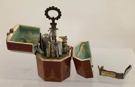 A 19TH CENTURY OCTAGONAL NECESSAIRE having top opening, floral and gilt decorated exterior with