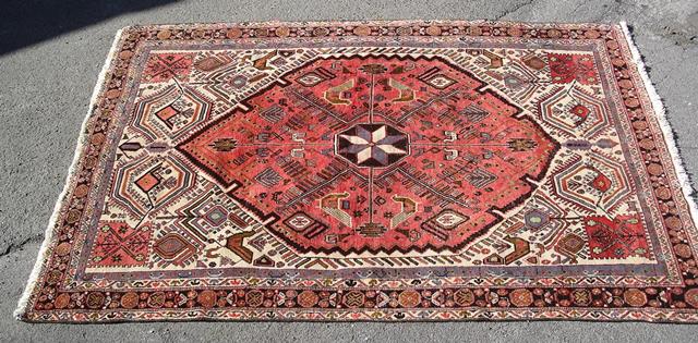 A PERSIAN RUG having serrated leaf and other desert flower motifs within a four guard border