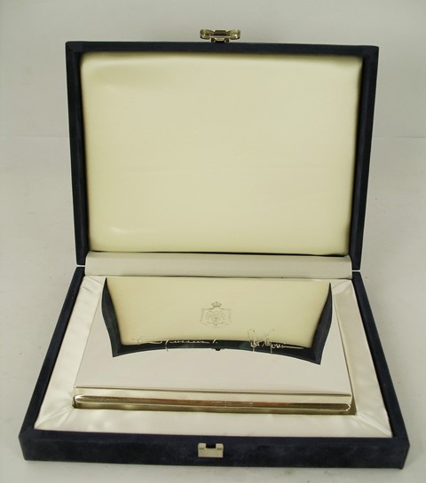 A GERMAN SILVER COLOURED METAL RECTANGULAR CIGARETTE BOX engraved with crest and facsimile