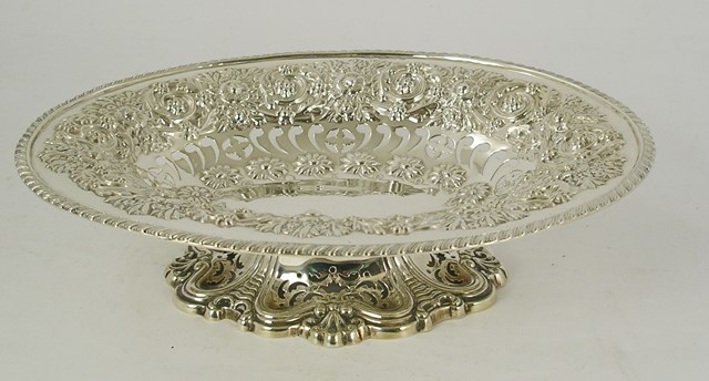 *** GLASS AN EDWARDIAN OVAL SILVER ELEVATED DISH having gadroon rim, and repousse floral and