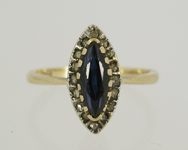 A SAPPHIRE AND DIAMOND GOLD COLOURED METAL DRESS RING having navette shape stone surrounded by