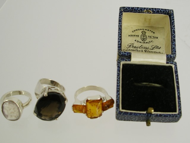 THREE FOREIGN SILVER COLOURED METAL RINGS, one set amber, another citrine and cameo, mixed sizes