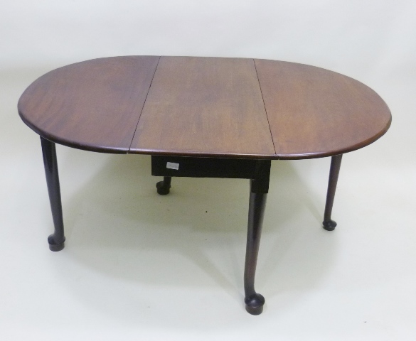 AN EARLY 19TH CENTURY MAHOGANY OVAL TOPPED TWIN FLAP DINING TABLE, supported on four slender legs,