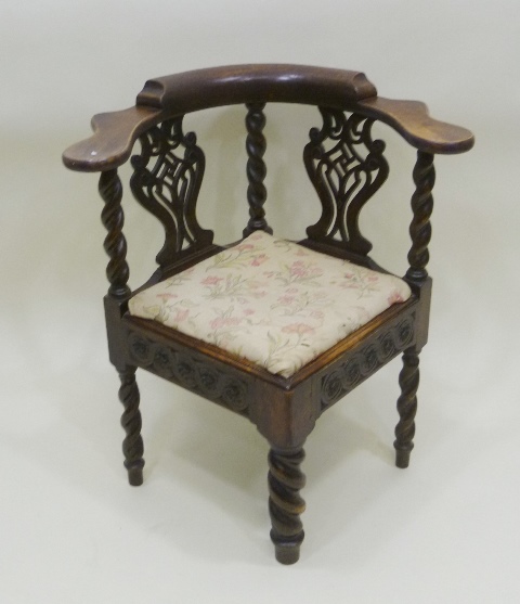 A 19TH CENTURY OAK FINISHED CORNER CHAIR with hump back, horse shoe arm supports and two fancy
