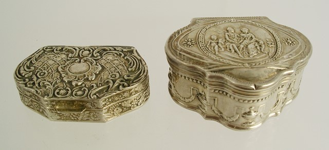 TWO FOREIGN SILVER COLOURED METAL PILL BOXES, one all over pressed decorated with urns and garlands