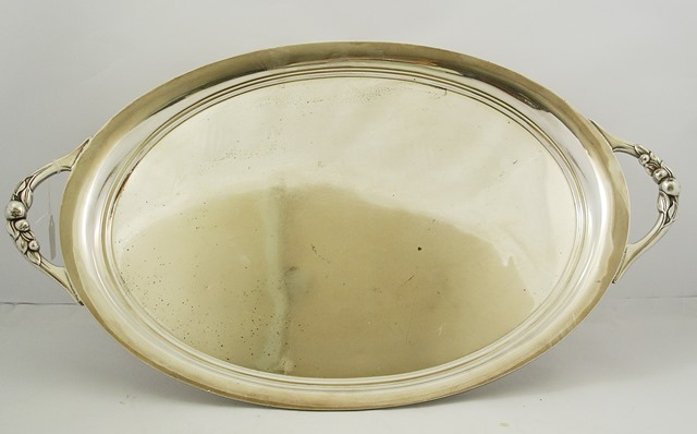 AN EPNS OVAL DRINKS TRAY of plain form, having twin cast fruit handles, 65.5cm wide