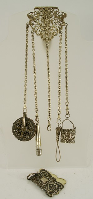 KING & SONS AN EDWARDIAN SILVER CHATELAINE, having cast and fretted belt clip, five chains holding